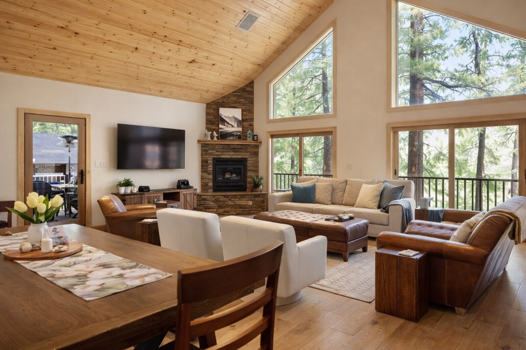 Bright open-concept living area at Bluejay Getaway cabin in Munds Park with vaulted wood ceiling and forest views