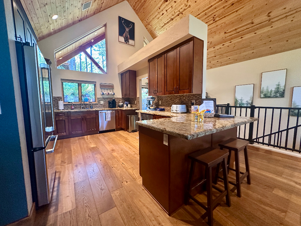 Bluejay Getaway kitchen with granite island and forest-view windows in Munds Park